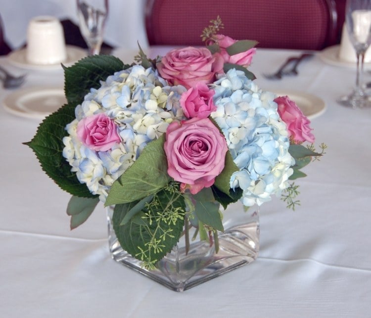 tischdeko-hortensien-hochzeit-weiss-blau-zart-rosen-pink-blaetter-gruen-vase-kristall-tischdecke