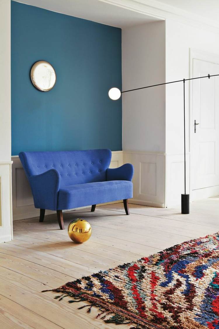 wandfarbe petrol akzentwand teppich bunt sofa blau
