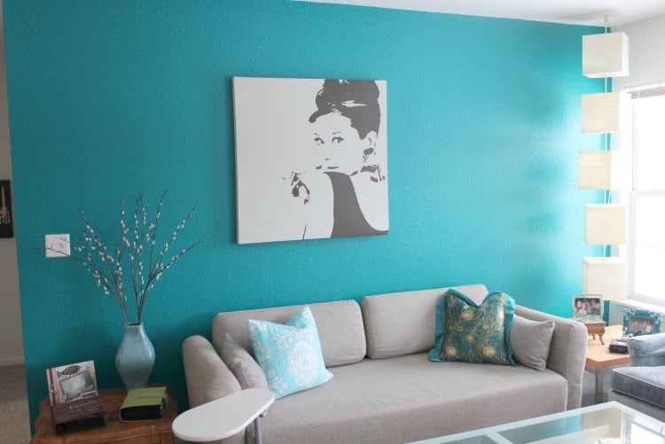wandfarbe-tuerkis-wohnbereich-couch-grau-bild-modern-kissen-deko-fenster