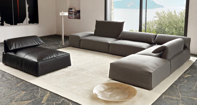 Sofa-Grau-Leder-hergestellt-Natursteinfliesen-Sandfarbe-Teppich