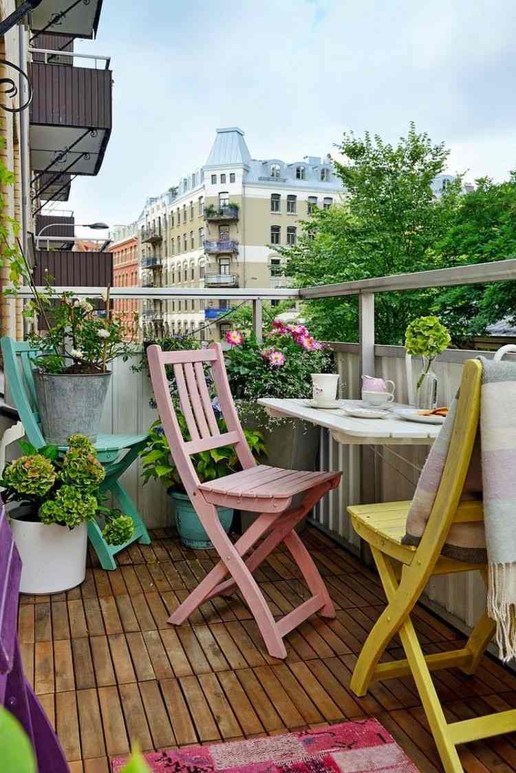 balkon-einrichten-holz-bodenfliesen-holz-klappstuehle-pastellfarben-hortensien