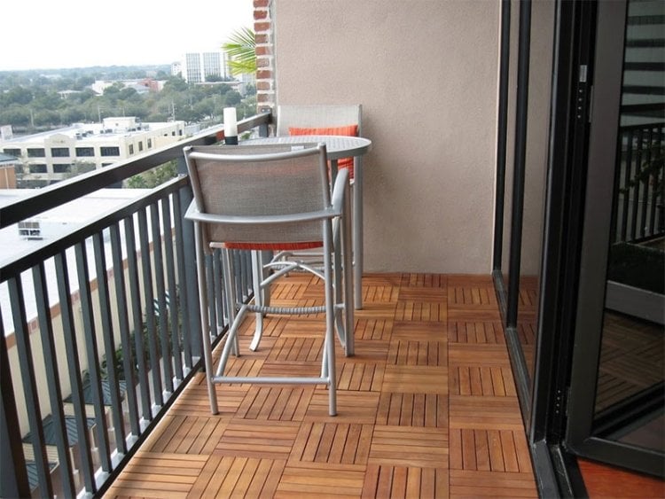 balkon-fliesen-holz--terrassentueren-stuehle-grau-metall-tisch-sitzkissen-orange