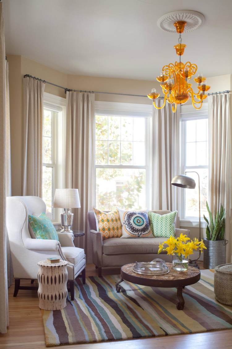 erkerfenster-dekorieren-pastellfarben-kronleuchter-gelb-teppich-couchtisch-sessel-couch