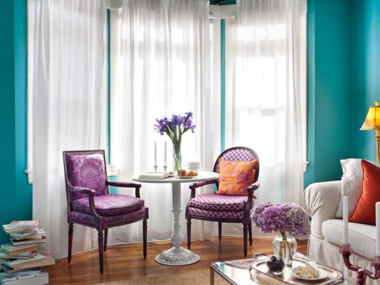 erkerfenster-dekorieren-wandfarbe-tuerkis-polsterstuehle-violett-beistelltisch-holzboden-gardinen-weiss