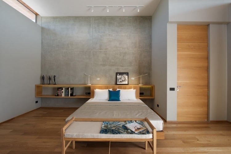 Leseleuchte am Bett -modern-schlafzimmer-betonwand-holz-minimalistischkopfteil-wendregal