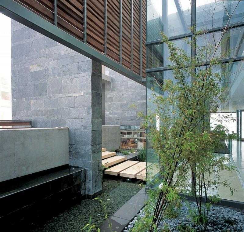 moderne-wohnideen-haus-innengarten-kies-wasser-naturstein-fensterwand-glas