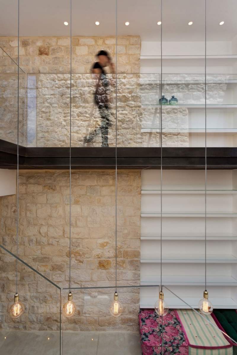 Natursteinwand innen und außen -mauerwerk-stahlseil-gluehbirne-leuchten-glasgelaender-etagen-regale-sitzkissen