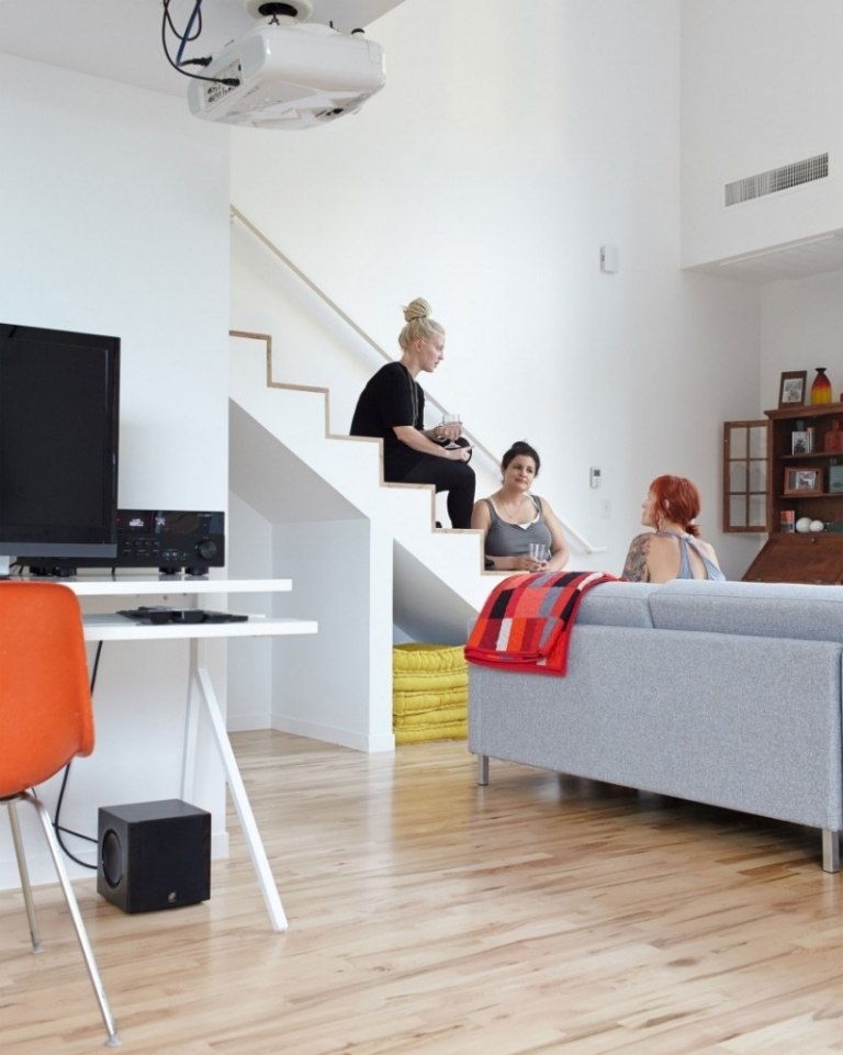 weisse-wandfarbe-treppe-offene-planung-wohnzimmer-parkettboden-frauen-moderne-einrichtung