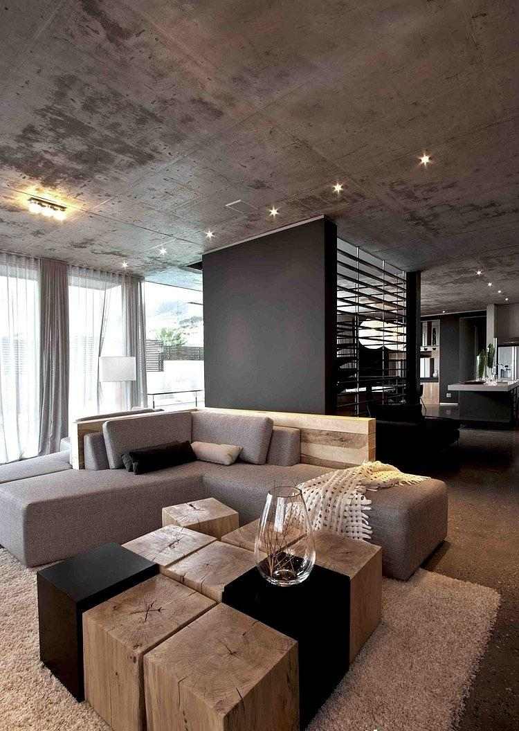 wohnzimmer-grau-eckcouch-baumstumpf-holzbloecke-couchtisch-betondecke-minimalistisch
