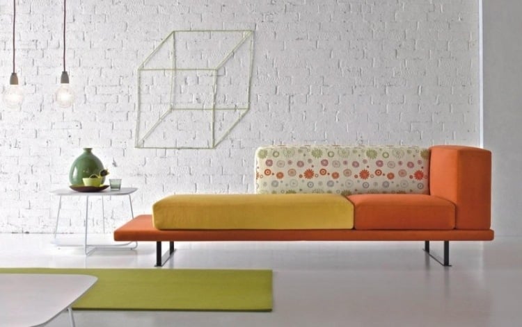 wohnzimmer-weiss-backsteinwand-geweisst-couch-tagesbett-orange-gelb-gluehbirne