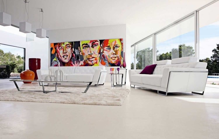 Wohnzimmer in Weiß -pop-art-portrait-bilder-farbig-teppich-weich-couches-fensterwand
