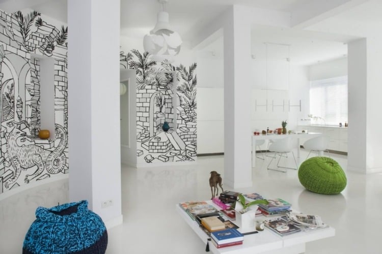 Wohnzimmer in Weiß -wandgestaltung-comics-poufs-minimalistisch-buecher-hund
