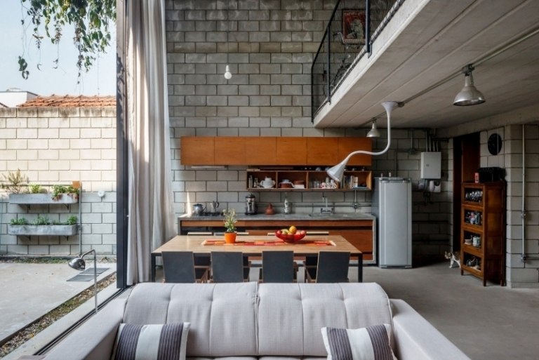 beton-design-modern-offene-kueche-holzfronten-couch-hellgrau-fensterwand-leuchten-industrial-stil-katze