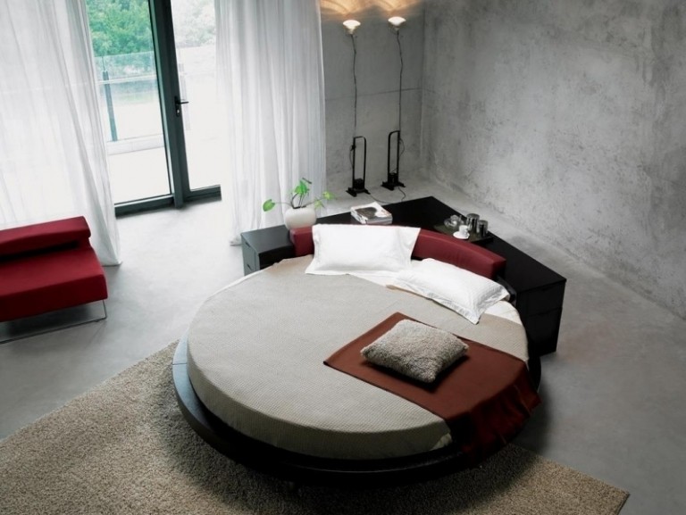 beton-design-modern-schlafzimmer-bett-rund-schwarz-rot-fenster-terrassentueren