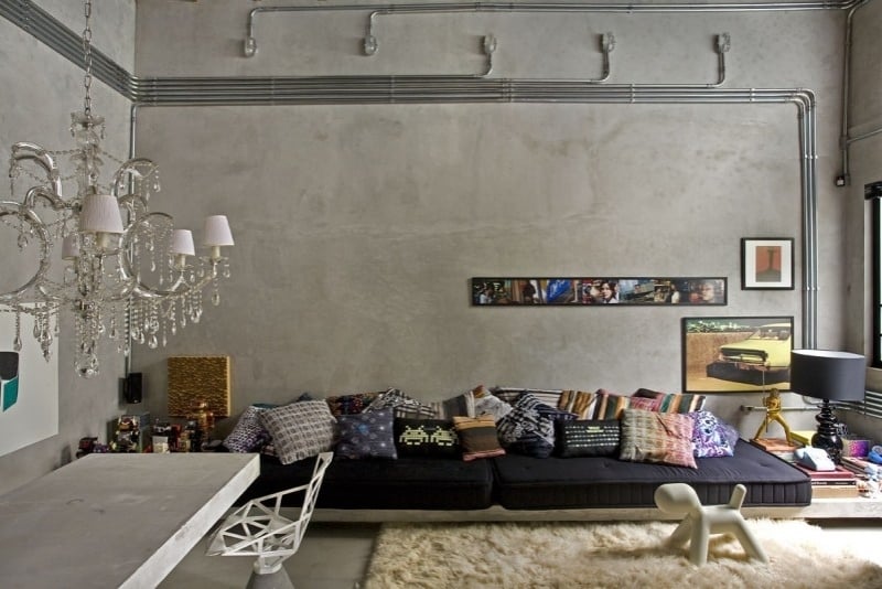 beton-design-modern-wohnzimmer-couch-kissen-weich-teppich-kronleuchter-kabel