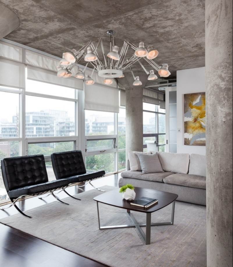 beton-design-modern-wohnzimmer-decke-kronleuchter-teppich-hellgrau-couch-sessel