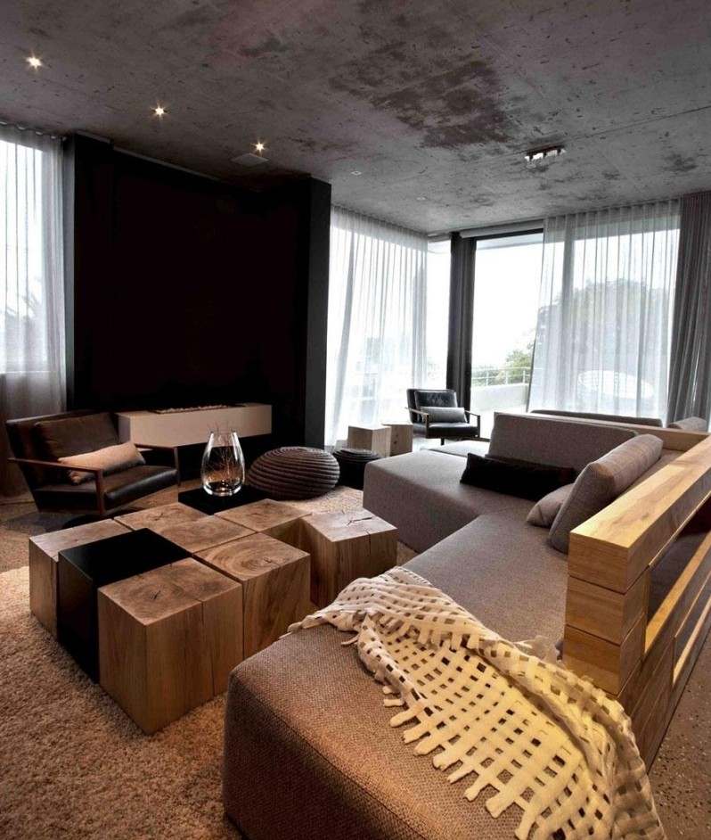 beton-design-modern-wohnzimmer-spots-betondecke-couch-braun-holz-couchtisch-holzbloecke-teppich