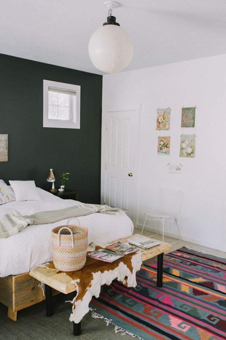 bohemian-style-schlafzimmer-weiss-kelimteppich-exotisch-holzbett-sitzbank-fellteppich-wandfarbe-schwarz