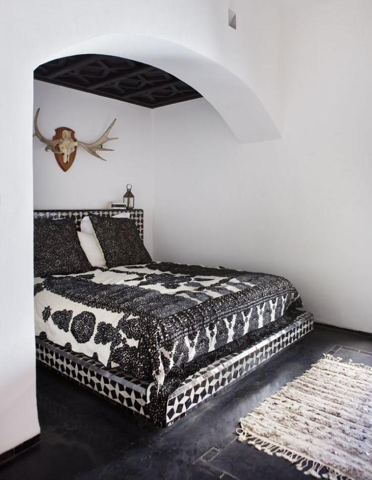 bohemian-style-schlafzimmer-weiss-schwarz-geweih-bett-fundament-mosaik-wandfarbe