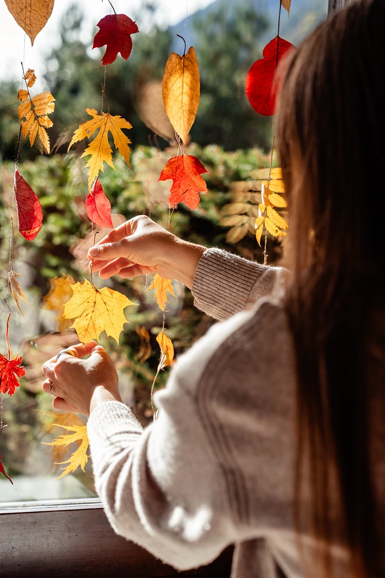 Girlanden aus Laubblättern herstellen und vor das Fenster hängen