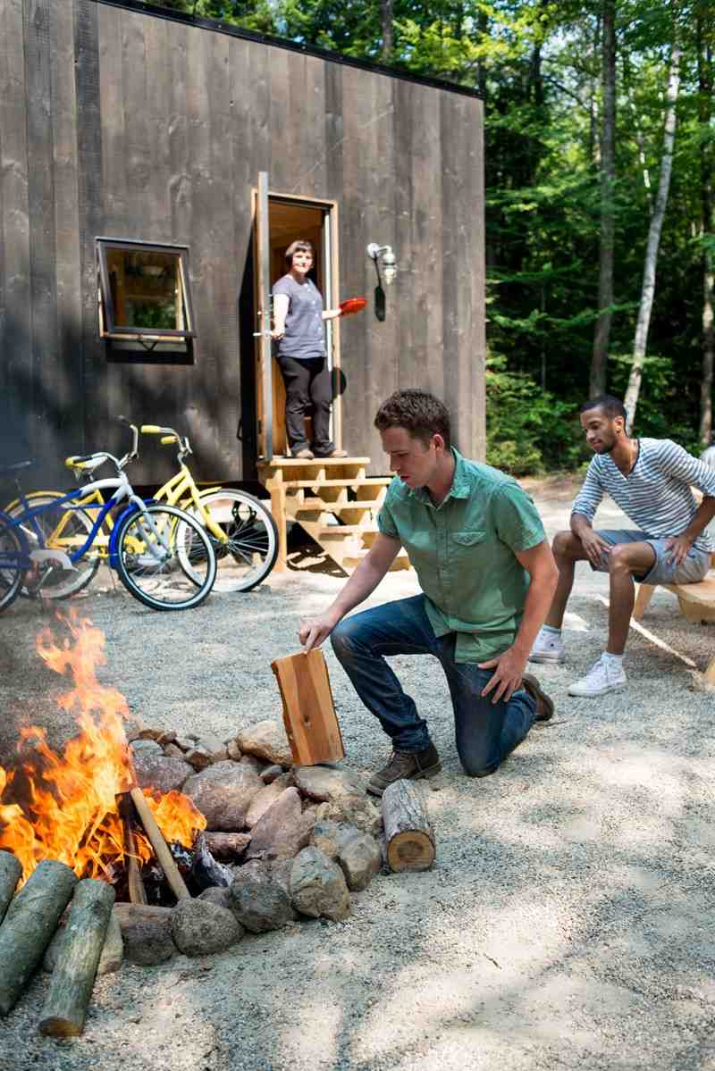 kleines-haus-outdoor-feuerstelle-brennholz-lager-fahrraeder-camping-ferien-natur-wald