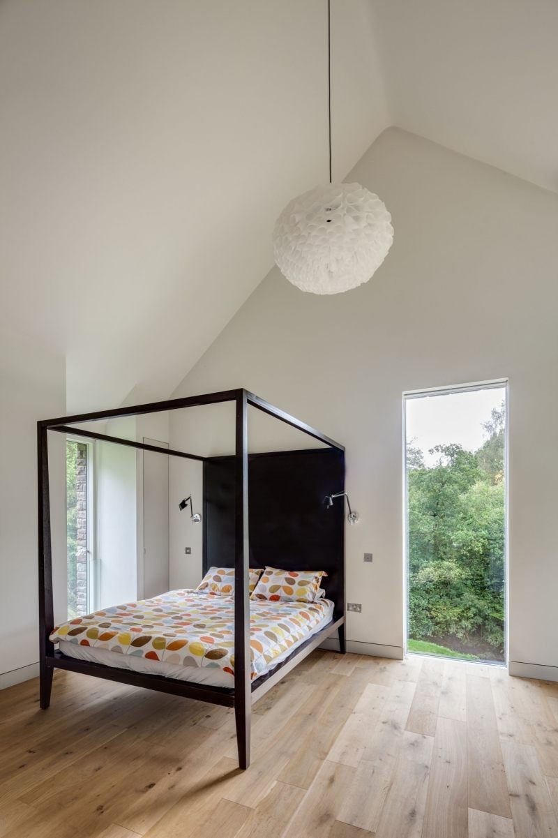 landhaus-stil-moderne-architektur-einrichtung-schlafzimmer-himmelbett-schwarz-minimalistisch-wand-fensterfronten-weiss-wandfarbe