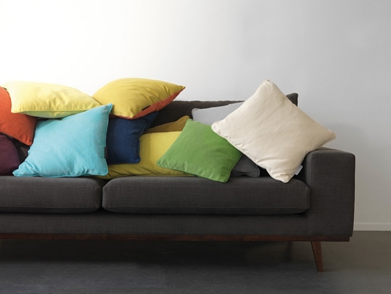 moderne-polsterstoffe-vorhaenge-moebel-couch-dunkelgrau-kissen-bunt-farbig-wandfarbe-weiss