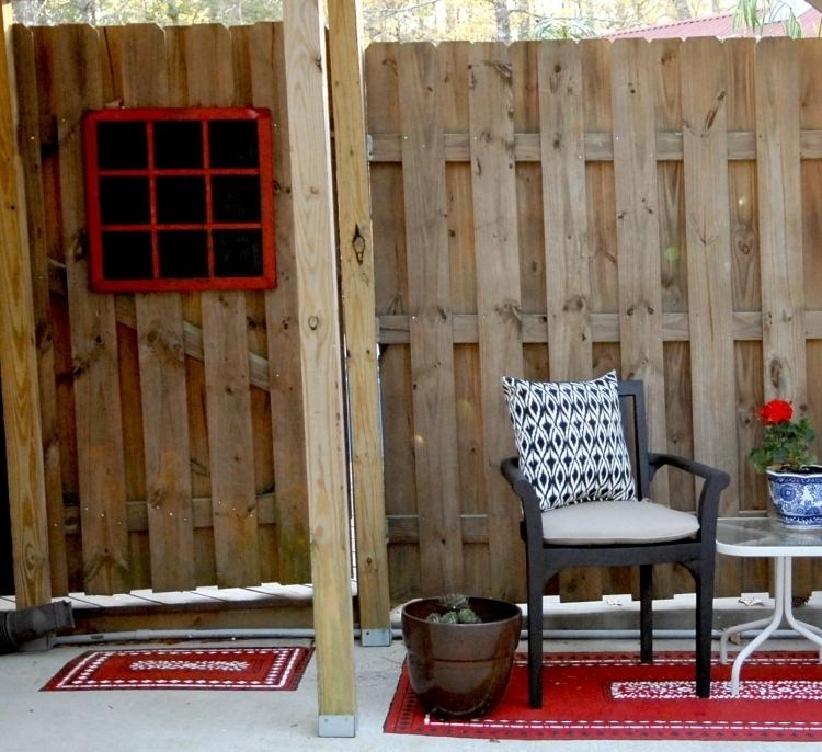 outdoor-teppiche-design-bunt-muster-rot-stuhl-kissen-sichtschutz-holzpaneele-pflanzkuebel