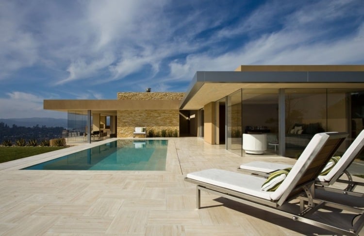 Travertin Fliesen outdoor-infinity-pool-liegen-glasfronten-schoenes-wetter-moderne-architektur