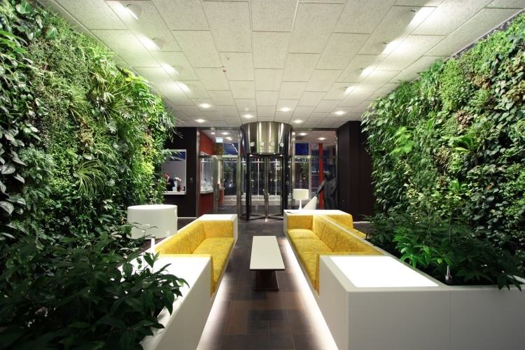 vertikaler-garten-couches-gelb-polster-indirekte-beleuchtung-modern-lobby-deckenpaneele