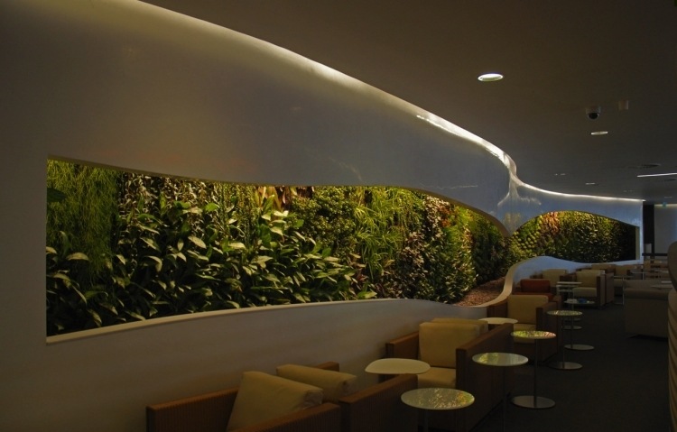 vertikaler-garten-wand-gefuehrt-sessel-tische-beleuchtung-spots-cafe-modern