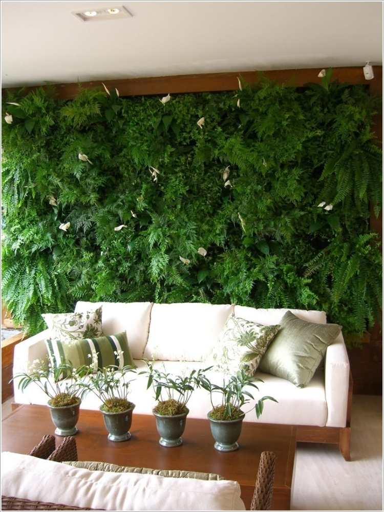 vertikaler-garten-wohnzimmer-couch-holz-couchtisch-kissen-gruenlich-spots-pflanzen