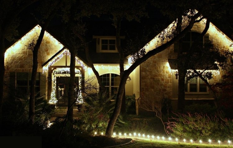 weihnachtsdeko-aussen-beleuchtet-haustuer--abends-lichter-gartenbaeume-pflanzen