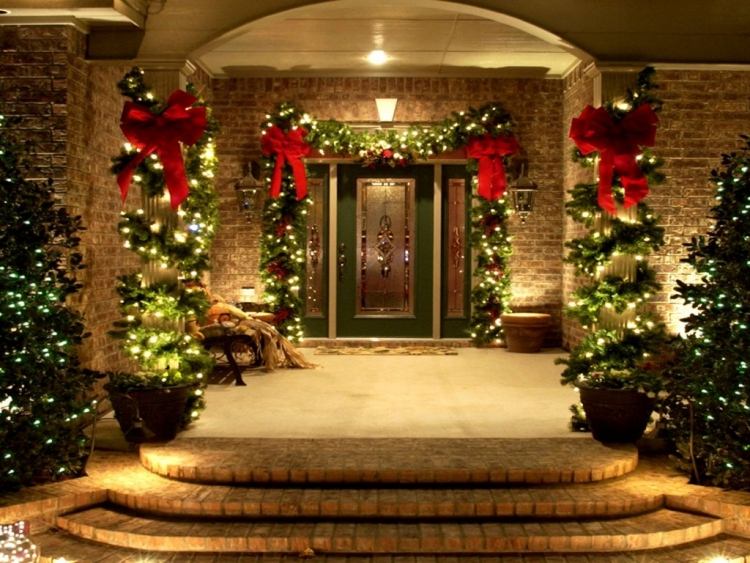 weihnachtsdeko-aussen-beleuchtet-haustuer-prchtvoll-tannenzweige-rote-baender-tannenbäume-zypressen