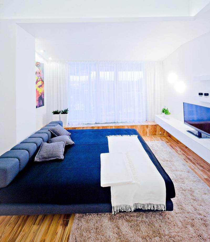 wohnen-blau-weiss-modern-wohnzimmer-tagesbett-fernseher-holzboden-design-funktional
