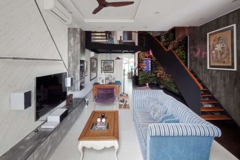 betonwande-innengarten-haus-singapur-wohnzimmer-treppe-vertikal-pflanzen-weiss-couch-blau