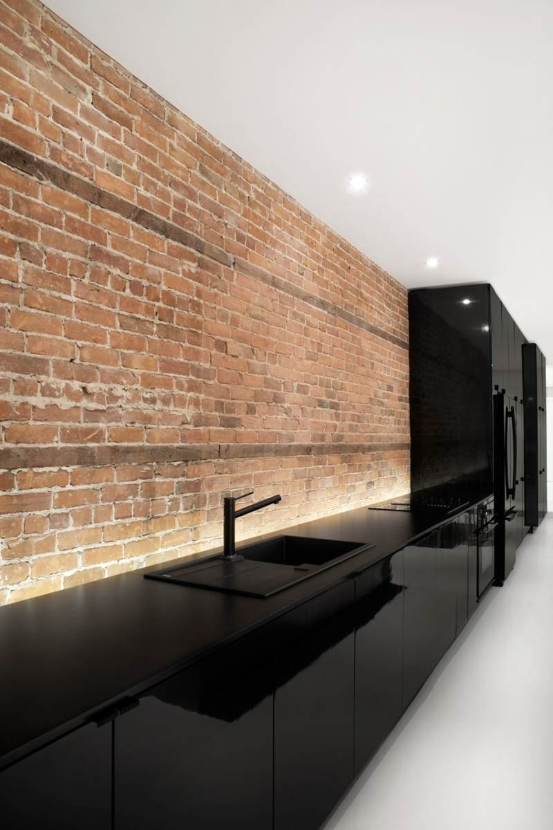 kueche schwarze minimalistisch spuele backstein wand design indirekte beleuchtung