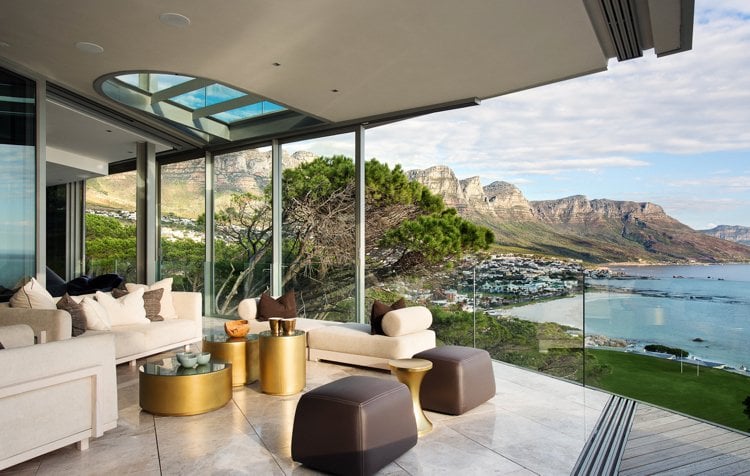 moderne-terrassenuberdachung-dachfenster-glasgelaender-gold-sitzmoebel-akzent