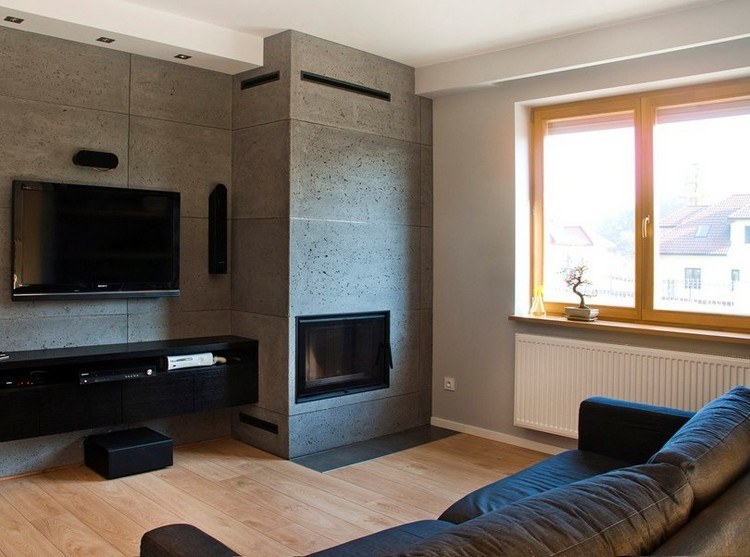 modernes-wohnzimmer-sofa-dunkelgrau-kamin-wandpaneele-betonoptik