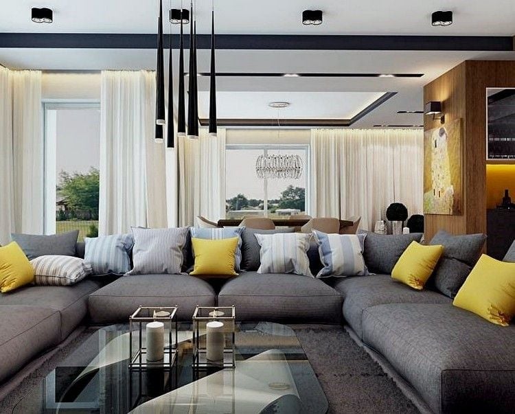 modernes-wohnzimmer-sofa-grau-gelbe-kissen-glas-couchtisch-schwarze-pendelleuchten