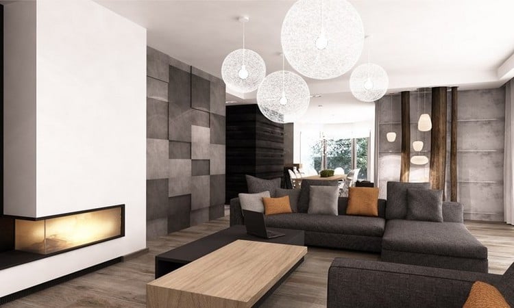 modernes-wohnzimmer-sofa-grau-holzboden-kaminwand-orange-kissen