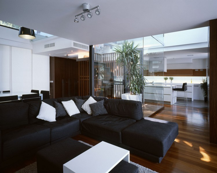 modernes-wohnzimmer-sofa-schwarz-dunkler-dielenboden-weisser-couchtisch