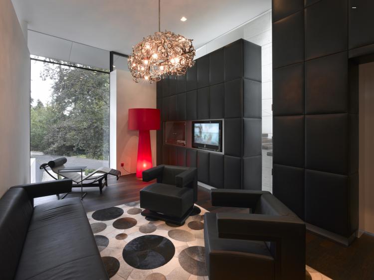 wandgestaltung-wohnzimmer-ideen-modern-extravagant-schwarz-polsterwand-sessel-kronleuchter