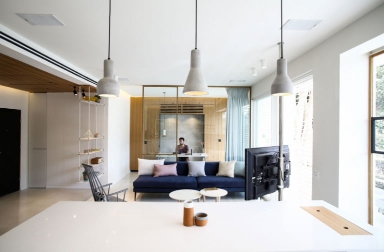 wohnung-einrichten-praktisch-modern-offen-wohnzimmer-kueche-dunkelblau-couch-pendelleuchten-beton