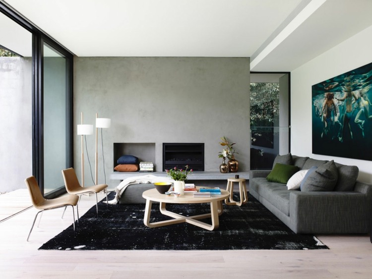 wohnzimmer teppiche schwarz minimalistisch einrichtung rund couchtisch wand beton optik