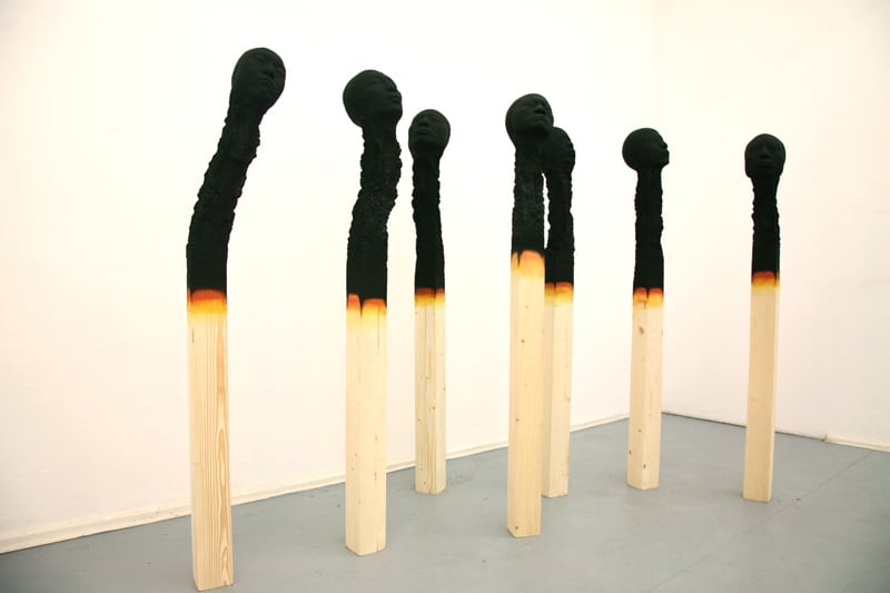 moderne-skulpturen-menschengesichter-matchstickmen-holz-kunstinstalation-gebrannt-kunst