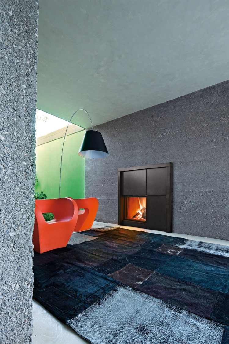 Kamin-modern-beton-waende-teppich-dunkel-used-look-sessel-rot-modell-matisse