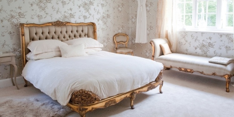 franzosischer-landhausstil-wohnaccessoires-schlafzimmer-antik-bett-kanapee-gold-tapete-floral