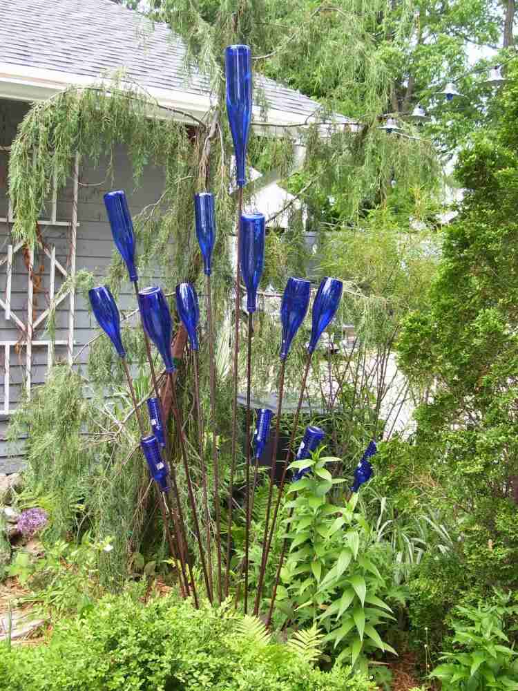 gartendeko-selber-machen-guenstig-glasflaschen-blau-sahl-staebe-pflanzen-boden