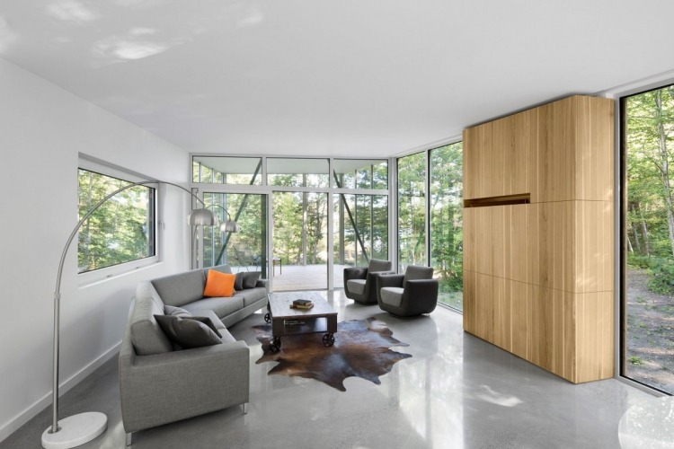 minimalistisch-wohnen-natur-modernes-haus-wohnzimmer-betonboden-couch-fellteppich-stehlampen